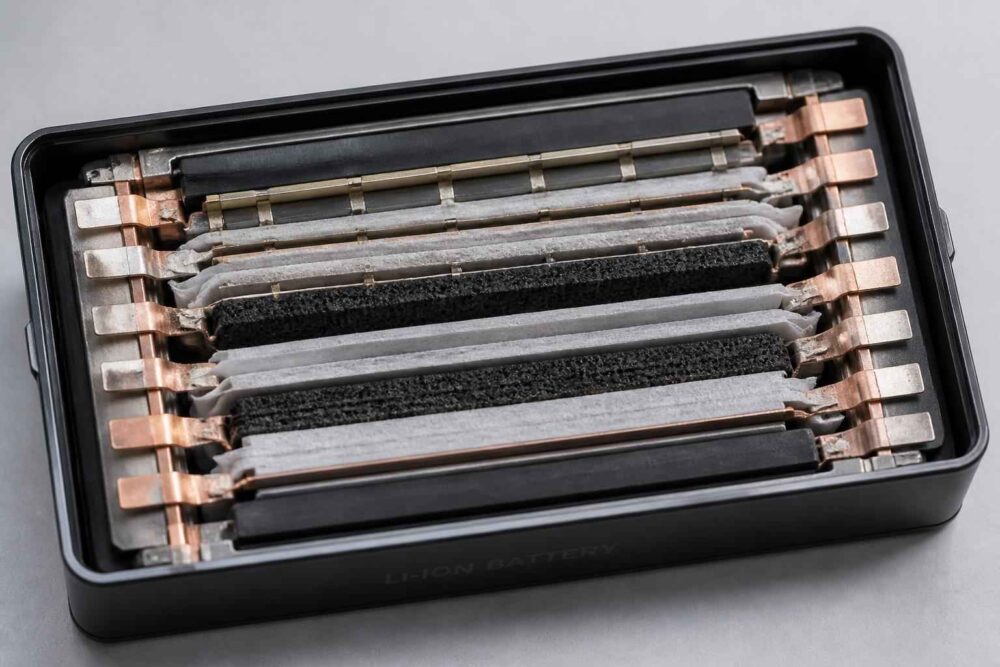 Otwarta kaseta magnetofonowa z widocznymi taśmami i elementami mechanizmu wewnątrz czarnej obudowy